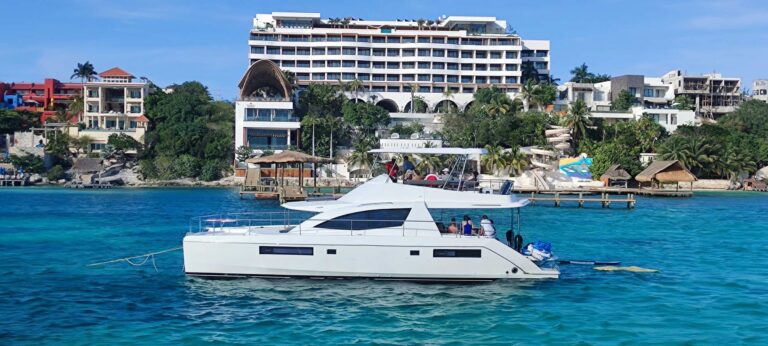 Aerial bow view of 51 ft Leopard power catamaran luxury yacht charter anchored in brilliant turquoise Caribbean water near Cancun, double-deck design