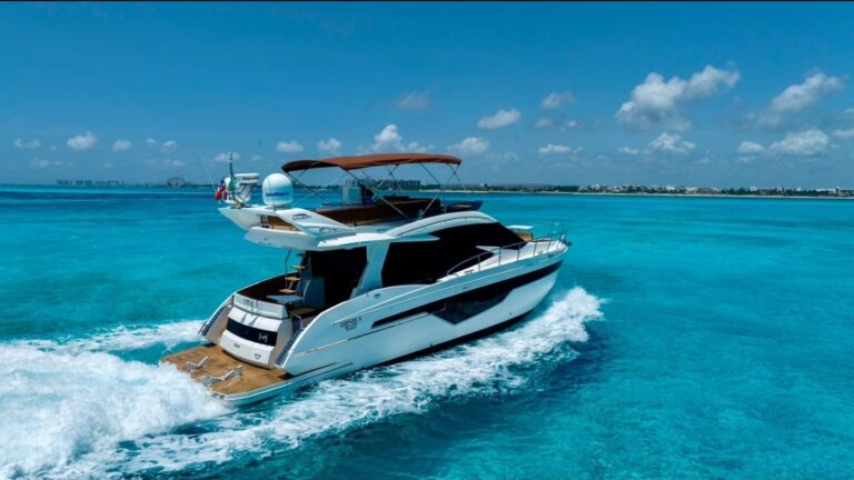 Overhead aerial view of 55 ft Galeon Zipsie luxury flybridge yacht charter anchored in vivid turquoise Caribbean water near Riviera Maya, showing expansive teak swim platform and flybridge