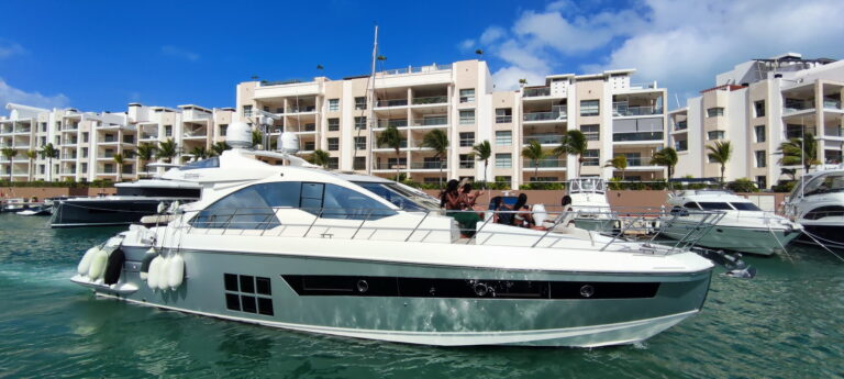 Bow three-quarter view of the 55 ft Azimut Sport yacht docked at La Amada marina, crew preparing for departure with radar array and flybridge visible