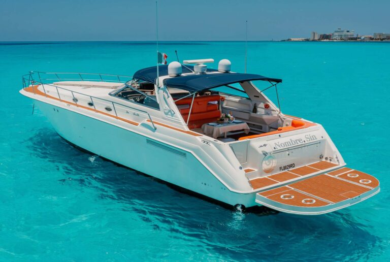 Aerial stern view of 55 ft Sea Ray Sin Nombre luxury yacht charter anchored in brilliant turquoise Caribbean water near Cancun, teak swim platform and orange cockpit seating visible