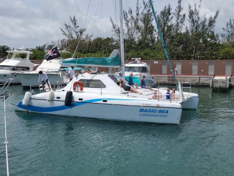 38 ft MagicSea Catamarans sailing yacht docked at Cancun marina with crew and guests waving aboard for a family snorkel charter