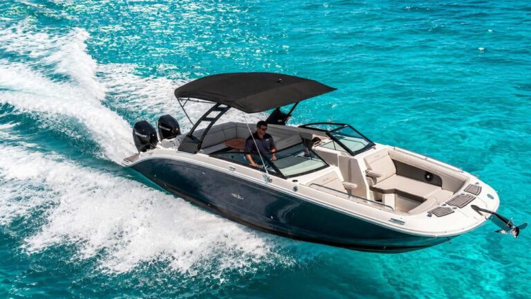 Aerial view of 29 ft Sea Ray Sport boat with black bimini top and dual Mercury outboards speeding through turquoise Caribbean water, luxury rental Cancun.